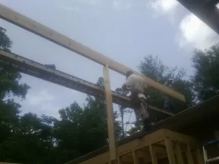 Carpenter setting a ridge beam over a new addition frame — Ice Dam Removal by Roofing Brothers in Lairdsville
