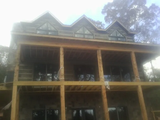 Dormers and porch framing on a large log home under construction — Roof Coating work by our crew in Lairdsville