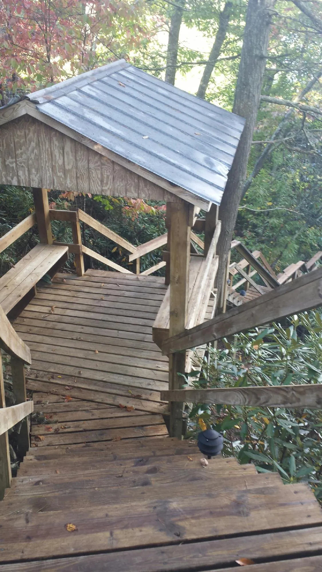 Metal roofed shelter over wooden steps on a wooded walkway — Skylight Repair & Installation work by our crew in Lairdsville