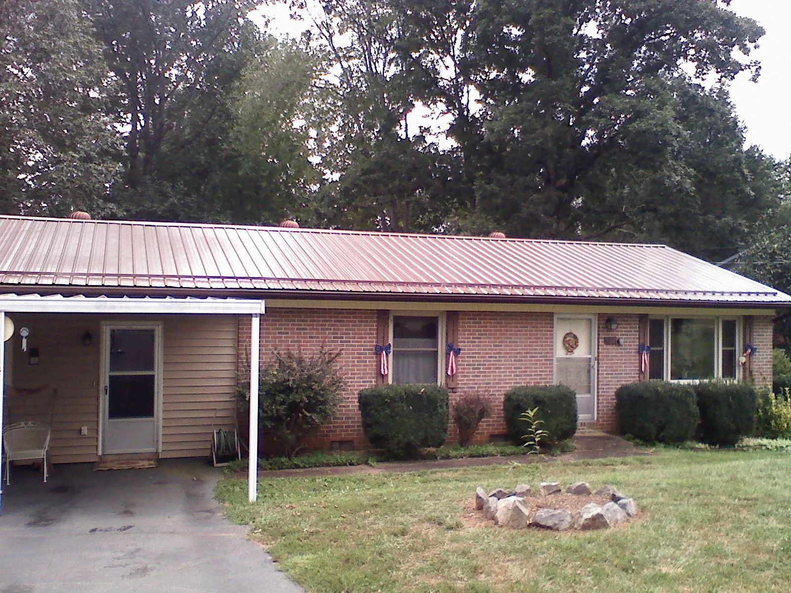 Bronze metal roof and carport on a brick ranch home — Roof Repair work by our crew in Lairdsville
